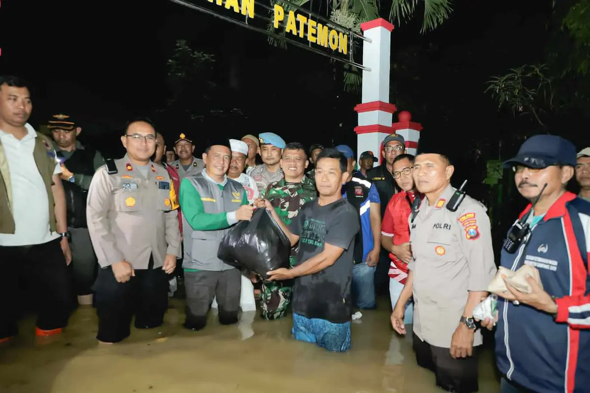 Penjabat (Pj) Bupati Pamekasan Masrukin membagikan bantuan untuk korban banjir. (Istimewa)