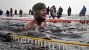 Seorang peserta tersenyum saat mengikuti kompetisi renang di perairan es di sungai Neva selama Big Neva Cup of Ice Swimming di St.Petersburg, Rusia, (4/3). (AP Photo/Dmitri Lovetsky)