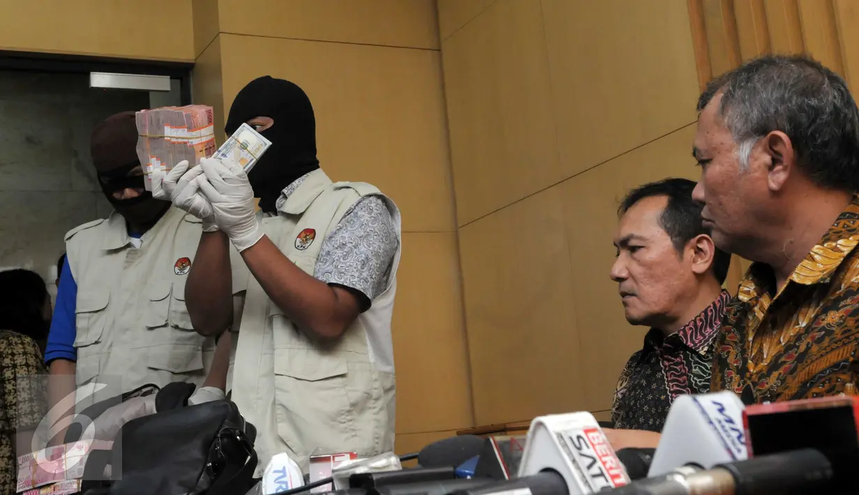 Petugas KPK menunjukkan barang bukti yang diperoleh dari operasi tangkap tangan (OTT) terkait dugaan suap DPRD DKI Jakarta disaksikan pimpinan KPK, Jakarta, Jumat (1/4). (Liputan6.com/Helmi Afandi)