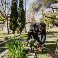 Ilustrasi nyekar, ziarah kubur. (Foto oleh RODNAE Productions: https://www.pexels.com/id-id/foto/pria-bunga-bunga-pohon-depresi-6841361/)