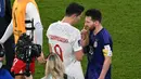 Dalam laga sebelumnya, tepatnya pada matchday pamungkas Grup C saat Polandia kalah 0-2 dari Argentina (1/12/2022), Robert Lewandowski juga kedapatan berbisik dengan Lionel Messi yang notabene juga merupakan pemain yang kini membela PSG. (AFP/Glyn Kirk)