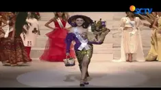 Kevin mengenakan kebaya ungu dihiasi bordir emas, lengkap dengan caping bambu dan bakul, berisi delapan botol jamu.