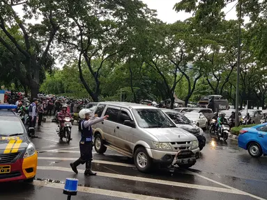 Petugas mengarahkan kendaraan yang melintasi kawasan SCBD usai balkon BEI ambruk, Jakarta, Senin (15/1). Ambruknya atap lobi balkon Bursa Efek Indonesia (BEI) membuat lalu lintas di sekitar SCBD macet. (Liputan6.com/Herman Zakharia)