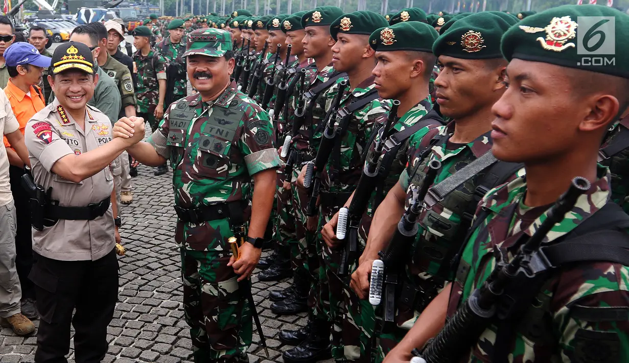 Panglima TNI Marsekal Hadi Tjahjanto dan Kapolri Jenderal Tito Karnavian melakukan salam Komando saat Apel Kesiapan Natal, Tahun Baru 2019 serta menjelang Pemilu legislasi dan Presiden 2019 di Monas, Jakarta, Jumat (30/11). (Liputan6.com/Johan Tallo)