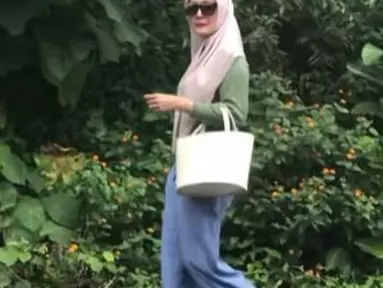 Memakai kacamata hitam, kulot jeans yang dipadu kaus lengan panjang berwarna hijau dan hijab panjang pink membuat Henidar Amroe tampak usia 40 tahun. (Foto: Instagram/@henidaramroe)