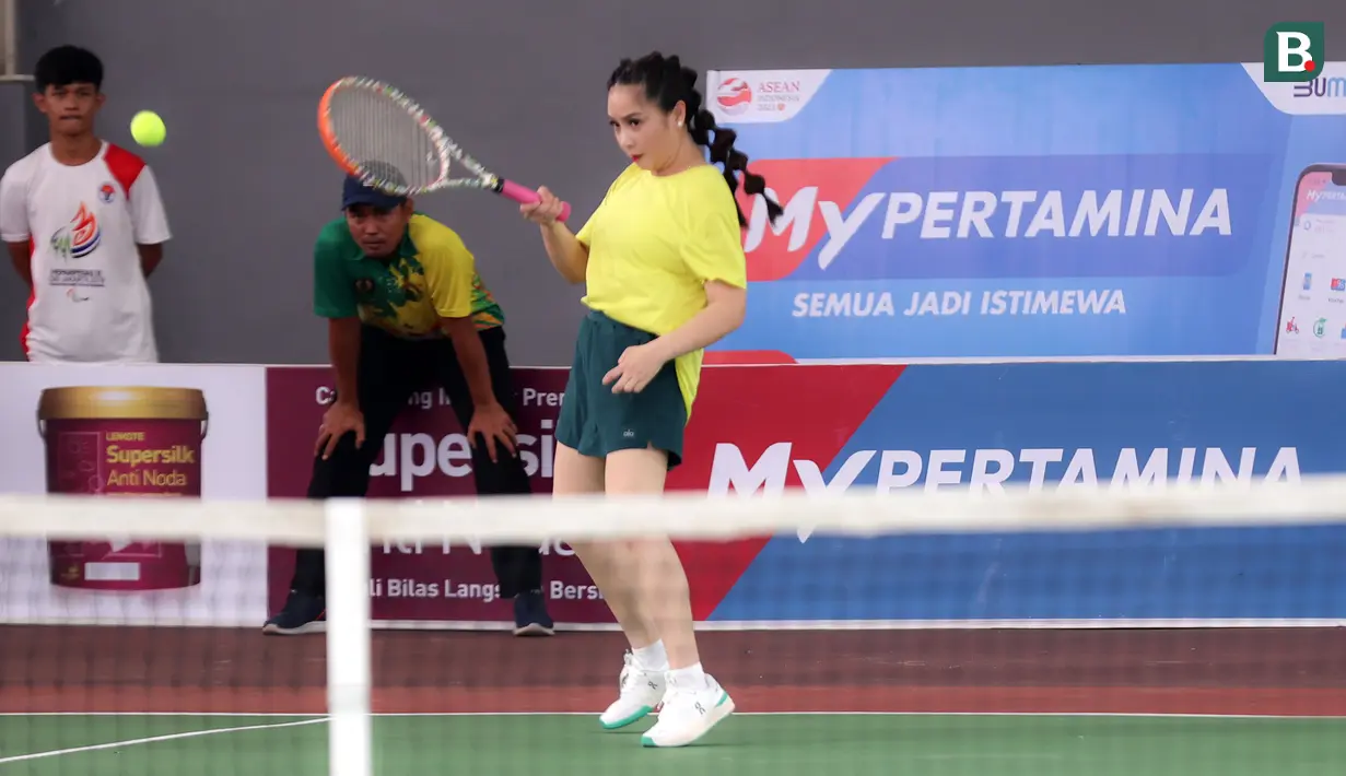 Selebritas Nagita Slavina berusaha mengembalikan bola pada laga tenis nomor ganda campuran Turnamen Olahraga Selebriti Indonesia (TOSI) yang digelar di GOR UNJ, Jakarta, Sabtu (15/07/2023). Gigi, sapaan Nagita Slavina, yang berpasangan dengan Ritchie Ismail atau dikenal sebagai Jeje Govinda kalah dari pasangan Gege dan Ibnu Jamil dua set langsung  (5-7, 6(2)-7(7)). (Bola.com/Abdul Aziz)