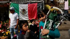 Seorang bocah membawa patung Santa Muerte atau The Saint of Death saat merayakan tahun baru di Meksiko, Minggu (1/1/2017). Warga Meksiko percaya jika berdoa kepada Santa Muerte akan membawa keberuntungan. (REUTERS/Carlos Jasso)