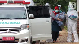 Warga diantar petugas paramedis  untuk menjalani isolasi mandiri bagi pasien positif  OTG di Rumah Melawan Covid-19 Tangerang Selatan, Jumat (1/1/2021). Akhir 2020, kasus Covid-19 baru di Tangerang Selatan (Tangsel) semakin meningkat. (merdeka.com/ Arie Basuki)