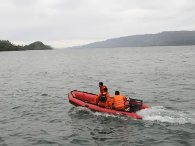 Tim penyelamat mencari korban hilang KM Sinar Bangun yang tenggelam di Danau Toba, Sumatera Utara, Selasa (19/6). Pencarian korban hilang sempat dihentikan akibat cuaca buruk. (AP Photo/Lazuardy Fahmi)