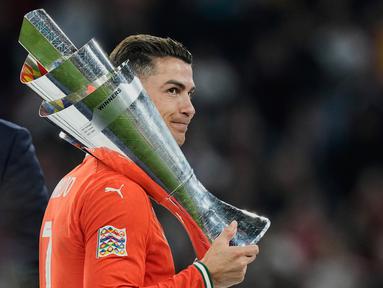 Pemain Portugal, Cristiano Ronaldo, mengangkat trofi saat menjuarai UEFA Nations League 2025 setelah menaklukkan Timnas Spanyol lewat drama adu penalti di Allianz Stadium, Senin (09/06/2025) dini hari WIB. (AP Photo/Martin Meissner)