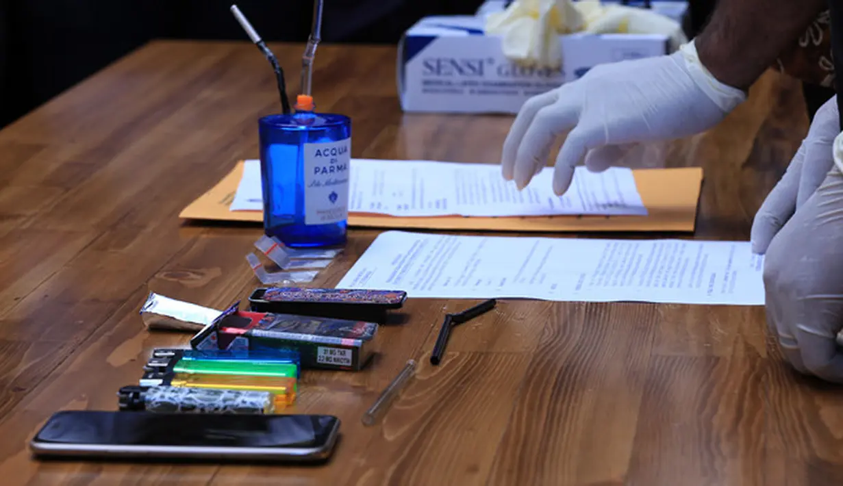 Tio ditangkap dengan barang bukti tiga bungkus plastik klip berisi Kristal Metamfetamin atau sabu dengan berat brutto 1,06 gram, bong, cangklong, satu buah handphone, dan korek api gas. Barang buktinya saat konferensi pers. (Deki Prayoga/Bintang.com)