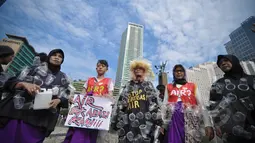 Sejumlah aktivis mengenakan kostum dari sampah plastik air mineral saat menggelar aksi Menolak Swastanisasi Air Jakarta di Bundaran HI, Jakarta, Minggu (22/3/2015). (Liputan6.com/Faizal Fanani)