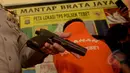 Petugas memperlihatkan sebuah senjata api jenis SIG Sever 262 9mm di Kepolisian Sektor Tebet Jakarta Selatan, Selasa (24/3/2015). Senjata api tersebut diamankan petugas dari tangan tersangka berinisial SH. (Liputan6.com/Johan Tallo)