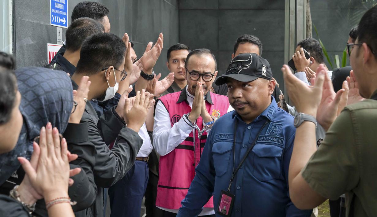 Vonis tersebut dibacakan majelis Hakim Pengadilan Tindak Pidana Korupsi, Jakarta, pada Kamis (26/2/2026). Tampak dalam foto, mantan Direktur Utama PT Pertamina Patra Niaga, Riva Siahaan (tengah), dikawal menuju ke ruang sidang untuk mendengar pembacaan vonis oleh majelis hakim Pengadilan Tindak Pidana Korupsi, Jakarta, Kamis (26/2/2026). (BAY ISMOYO/AFP)