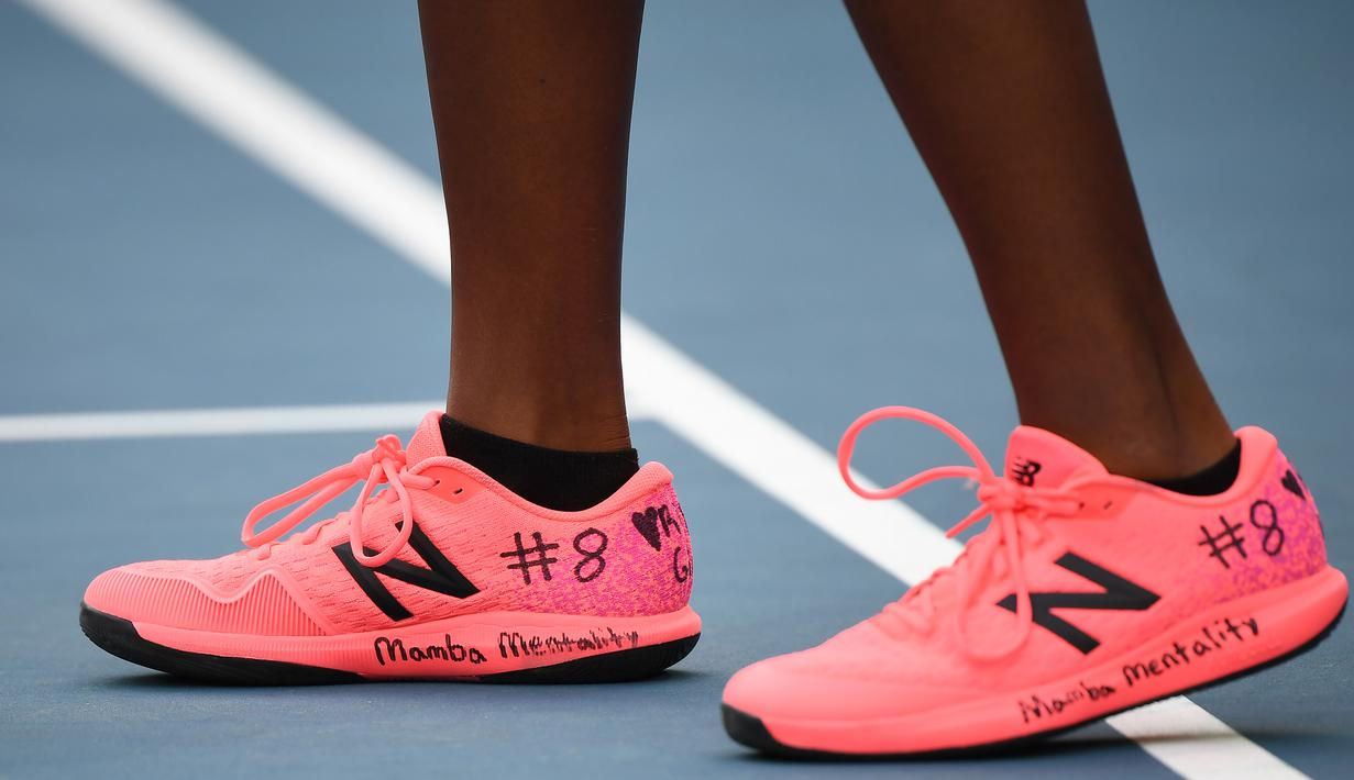 Petenis Amerika Serikat, Coco Gauff, mencoret sepatunya dengan nomor punggung Kobe Bryant saat laga Australia Open di Melbourne, Australia, Senin (27/1). Akibat kecelakaan helikopter, legenda NBA itu wafat bersama sang putri. (AFP/Manan Vatsyayana)