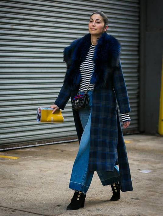 Di hari-hari yang dingin kamu bisa memadukan kulot jeans dengan mantel dan sepatu boot untuk menghadirkan statement look. Foto: whowhatwear.