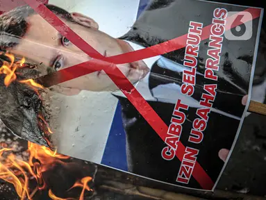 Massa dari berbagai elemen ormas Islam menginjak dan membakar poster Presiden Prancis Emmanuel Marcon di kawasan Sarinah, Jakarta, Senin (2/11/2020). Demonstrasi ini untuk mengecam Emanuel Macron atas pernyataannya yang dinilai telah menghina Islam dan Nabi Muhammad SAW. (Liputan6.com/Faizal Fanani)