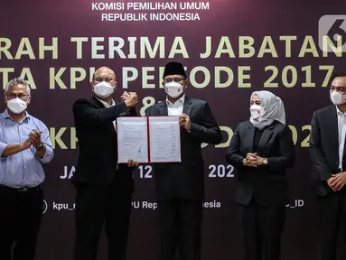 Ketua Komisi Pemilihan Umum (KPU) Hasyim Asy'ari (kanan) melakukan sertijab dengan Ketua KPU periode 2017-2022 Ilham Saputra di Gedung KPU, Jakarta, Selasa (12/4/2022). Presiden Joko Widodo resmi melantik ketujuh komisioner KPU untuk bertugas dalam periode 2022-2027. (Liputan6.com/Johan Tallo)