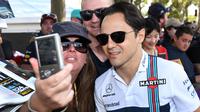 Seorang penggemar melakukan selfie dengan pembalap kawakan asal Tim Williams, Felipe Massa menjelang sesi latihan bebas pertama di Grand Prix Australia, Melbourne, Jumat (24/3). (AFP Photo/WILLIAM WEST)