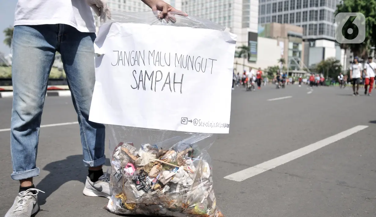 Aktivis yang tergabung dalam Sekolah Relawan memunguti sampah saat aksi Jakarta Clean Action selama Hari Bebas Kendaraan Bermotor (HBKB) di kawasan Bundaran HI, Jakarta, Minggu (1/12/2019). (merdeka.com/Iqbal S. Nugroho)
