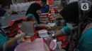 Petugas Taruna Siaga Bencana menyiapkan nasi kotak di Dapur Umum Kementerian Sosial Peduli Dampak Covid-19 di Kompleks Gedung Konvensi TMP Nasional-Utama, Kalibata, Jakarta, Rabu (8/4/2020). Paket nasi itu didistribusikan ke warga DKI yang terdampak pandemi Covid-19. (Liputan6.com/Faizal Fanani)