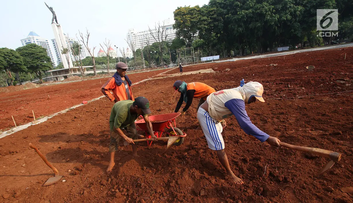 Pekerja mencangkul tanah untuk menyelesaikan pengerjaan proyek revitalisasi Lapangan Banteng di Jakarta Pusat, Rabu (1/11). Pemprov DKI Jakarta melakukan revitalisasi Lapangan Banteng yang dibagi menjadi tiga segmen. (Liputan6.com/Immanuel Antonius)