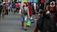 Warga membawa barang belanjaan dengan menggunakan kantong plastik di Kawasan Pasar Jatinegara, Jakarta, Selasa (30/6/2020). Pemerintah Provinsi DKI Jakarta bakal resmi menerapkan larangan penggunaan kantong plastik sekali pakai mulai Rabu, 1 Juli 2020 besok. (Liputan6.com/Faizal Fanani)