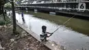 Seorang anak saat memancing di Kali Ancol, Jakarta Utara, Kamis (11/3/2021). Kali Ancol menjadi wisata alternatif warga, terutama bagi yang hobi memancing untuk menghabiskan waktu liburan. Selain orang dewasa, sejumlah anak-anak pun terlihat asyik memancing di Kali Ancol. (merdeka.com/Iqbal S. Nugro