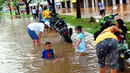 Hujan yang turun sejak Minggu (8/2), mengakibatkan kawasan perumahan Garaharaya di Tangerang, Banten terendam air. Beberapa warga memanfaatkan genangan air untuk membersihkan sepeda motor, Selasa (10/2/2015). (Liputan6.com/Faisal R Syam)