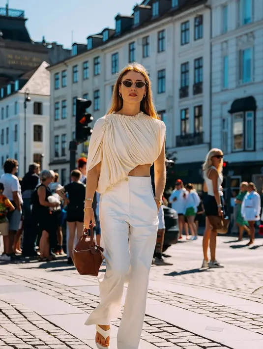Wide leg pants sempurna dipasangkan dengan tube top seperti terlihat pada foto ini. Padukan dengan sepasang sandal jepit platform dan tas bernuansa netral.