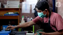 Kru membersihkan sepatu pelanggan di Soul Sepatu di kawasan Rawamangun, Jakarta, Senin (9/11/2020). Dalam sehari, mereka mampu menyelesaikan 20 pasang sepatu, yang dimulai dari harga Rp35 ribu hingga Rp75 ribu. (Liputan6.com/Faizal Fanani)