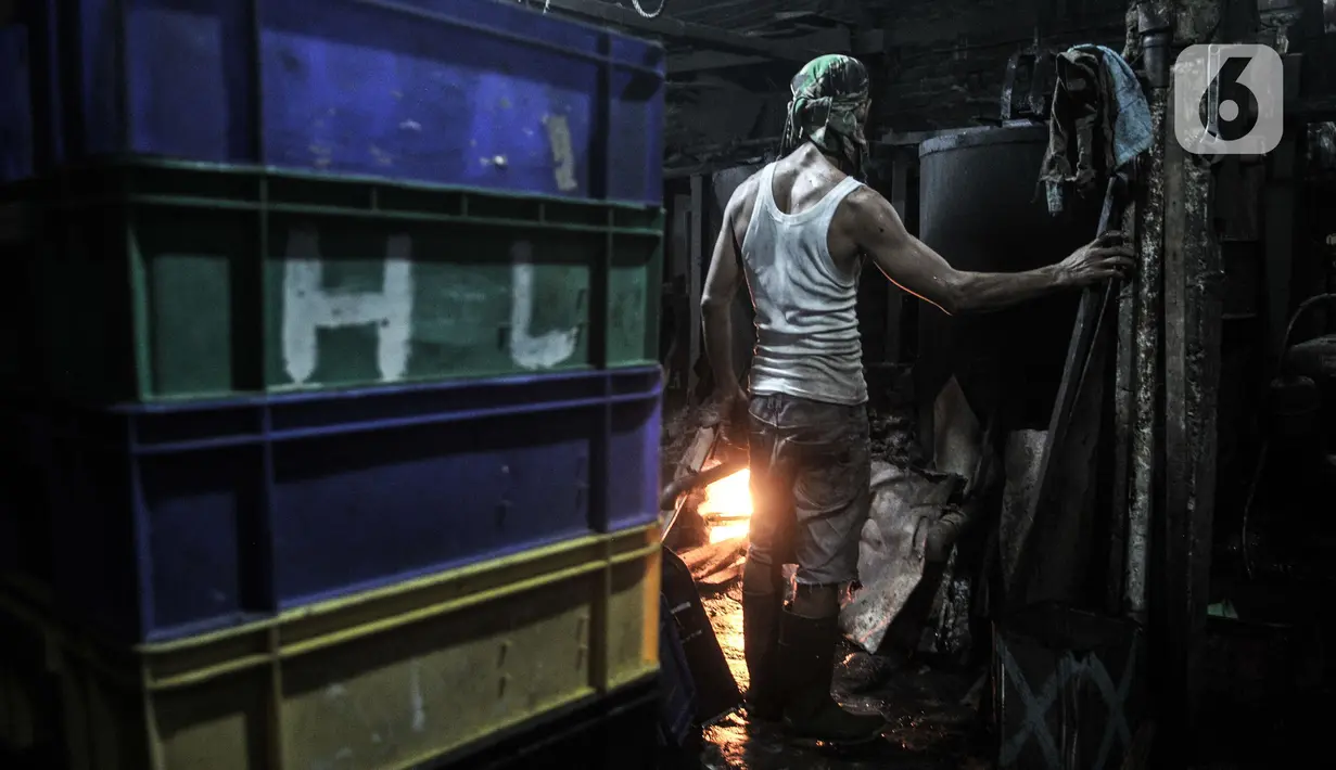 Pekerja saat mengatur api tungku yang menggunakan kayu bakar saat menyelesaikan produksi cincau hitam di industri rumahan kawasan Jatinegara, Jakarta Timur, Rabu (14/4/2021). (merdeka.com/Iqbal S. Nugroho)