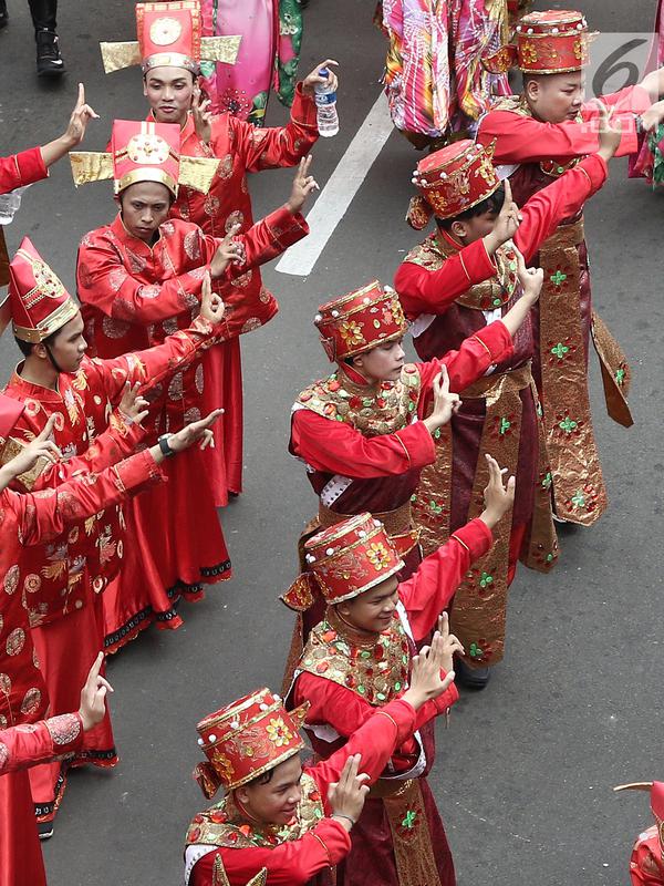 Peserta memakai kostum tradisional saat meramaikan pawai obor Asian Para Games 2018 di Jakarta, Minggu (30/9). Pawai obor dimulai dari Balai Kota DKI Jakarta dan berakhir di Gedung Kementerian Pemuda dan Olahraga. (Liputan6.com/Herman Zakahria)