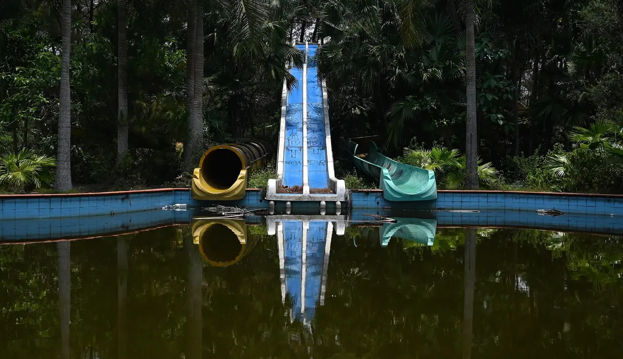 Foto pada 27 April 2019 memperlihatkan seluncuran air telantar di Taman Air Ho Thuy Tien yang telah lama ditinggalkan di kota Hue, Vietnam. Saat mengunjunginya, taman air ini tampak ditinggalkan, tak terurus, dan terkesan angker. (Manan VATSYAYANA/AFP)