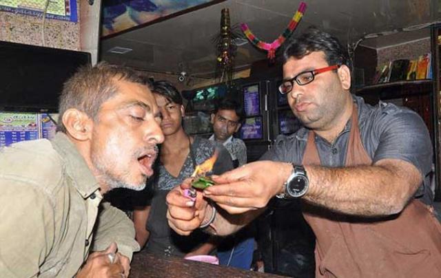 Pelanggan paan makan paan yang sedang dibakar | Photo: Copyright odditycentral.com