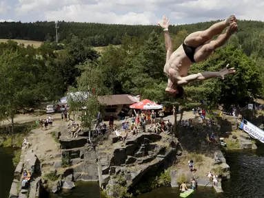 Seorang peserta melompat ke dalam air saat kompetisi cliff diving di kawasan Bohemian, Republik Ceko, Jumat (31/7/2015). (REUTERS/David W Cerny)