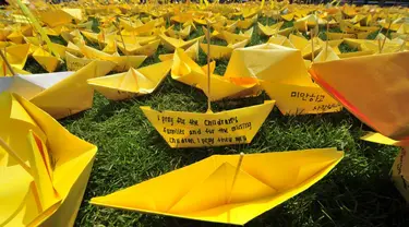 Pesan-pesan untuk mengenang korban feri Sewol ditulis dalam kertas kuning berbentuk kapal di Balai Kota Seoul, Rabu (7/5/14). (AFP PHOTO/JUNG YEON-JE)