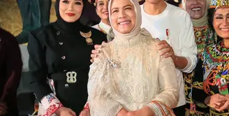 Iriana Jokowi tampil menawan mengenakan kebaya kurung brokat warna krem yang simple dan hijab nuansa senada.