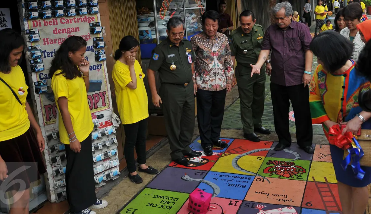 Slamet Raharjo dan sejumlah warga melihat seni mural di trotoar Cikini, Jakarta, Senin (14/12/2015). Mural yang dibuat di atas trotoar sepanjang 120 meter ini merupakan rangkaian kegiatan Fun Actv Art Mural 2015. (Liputan6.com/Gempur M Surya)