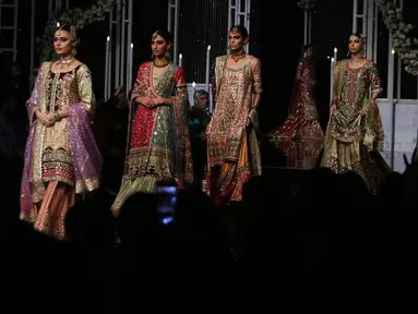Model membawakan busana rancangan desainer Annus Abrar  selama Bridal Couture Week di Lahore, Minggu (9/12). Para model cantik memperagakan kreasi gaun pengantin dari sejumlah desainer ternama di Pakistan. (AP Photo/K.M. Chaudary)