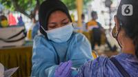 Petugas medis menyuntikkan vaksin Covid-19 pada warga dalam program vaksinasi massal Covid-19 di PMI Kota Bekasi, Jawa Barat, Sabtu (21/08/2021). PMI Kota Bekasi bekerjasama dengan Puskesmas Marga Jaya melaksanakan vaksinasi Covid-19 secara massal untuk 2000 peserta. (Liputan6.com/Herman Zakharia)