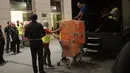 Polisi Malaysia membawa kardus berisi tas mewah dalam penggeledahan di tiga apartemen mantan Perdana Menteri, Najib Razak di Kuala Lumpur, Jumat (18/5). Polisi menyita 284 tas tangan mewah termasuk Hermes dan Birkin. (ARIFFIN JAMAR/THE STRAITS TIMES/AFP)