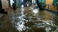 Hujan deras yang mengguyur wilayah Kabupaten Tangerang, Banten, mengakibatkan banjir merendam sejumlah perumahan saat Hari Raya Idul Fitri 1443 Hijriyah. (Pramita Tristiawati/Liputan6)