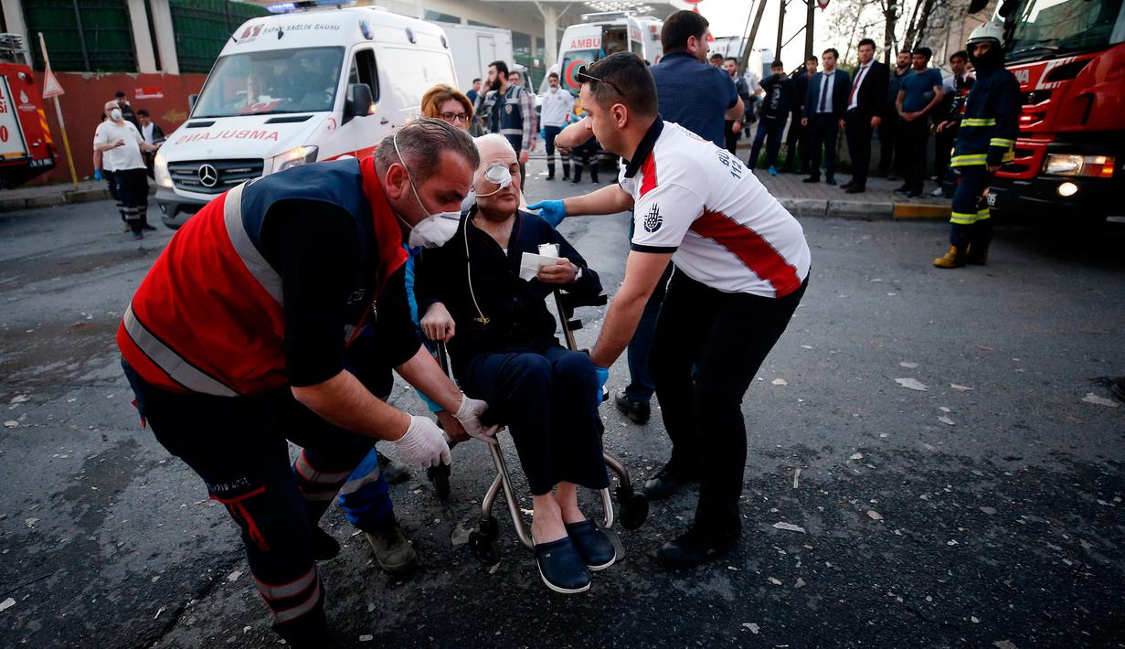 Petugas medis mengevakuasi seorang pasien setelah terjadi kebakaran di rumah sakit di distrik Gaziosmanpasa, Istanbul, Turki (5/4). Sebanyak 70 pasien dievakuasi dari peristiwa ini. (AP Photo/ Emrah Gurel)