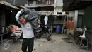 Warga memanggul plastik berisi barang miliknya dari rumah yang akan dibongkar di kawasan Kalijodo, Jakarta, Kamis (18/2). Gubernur DKI hari ini mengirim SP 1 kepada warga untuk mengosongkan dan membongkar sendiri rumah mereka (Liputan6.com/Gempur M Surya)