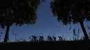 Sliuet aksi pebalap Tour de France melintasi pepohonan rindang pada etape ke-14 dengan jarak tempuh 181,5 km antara Blagnac and Rodez, (15/7/2017). (AFP/Jeff Pachoud)