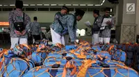 Panitia memeriksa koper para calon jemaah haji Kloter 1 di Asrama Haji Pondok Gede, Jakarta, Senin (16/7). Sebanyak 388 calon jemaah haji asal Jakarta Timur telah mulai masuk ke asrama. (Merdeka.com/Iqbal Nugroho)