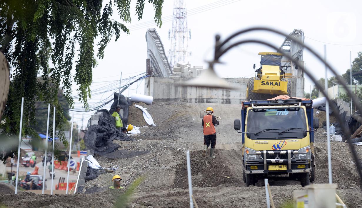 Aktivitas pekerja saat menyelesaikan proyek pembangunan jembatan di atas Jalan Tol Serpong-Cinere di Serua, Tangerang Selatan, Banten, Kamis (12/11/2020). Jembatan tersebut dibangun untuk menghubungkan jalan utama Serua dan Ciater. (merdeka.com/Dwi Narwoko)