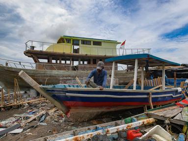 Warga menyelesaikan pembuatan perahu baru nelayan di Kampung Nelayan Tanjung Pasir, Tangerang, Banten, Rabu (22/1/2025). (merdeka.com/Arie Basuki)