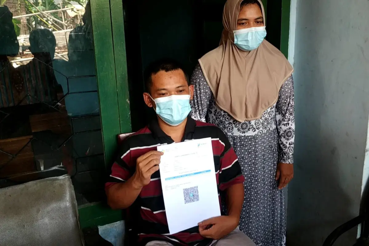 Joko Santoso menunjukkan sertifikat vaksin miliknya.  (Zainul Arifin/Liputan6.com)